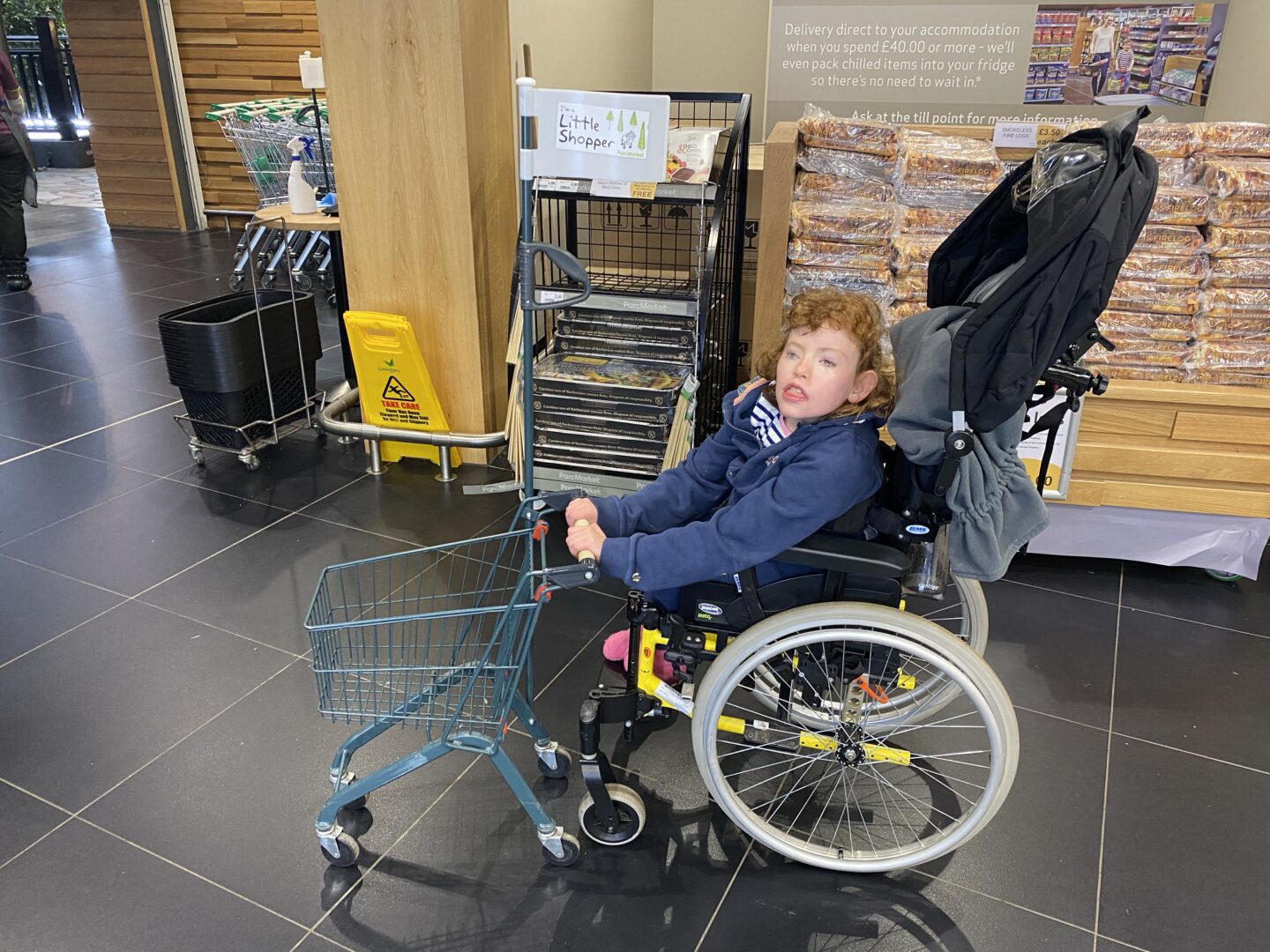 child in wheelchair with trolley