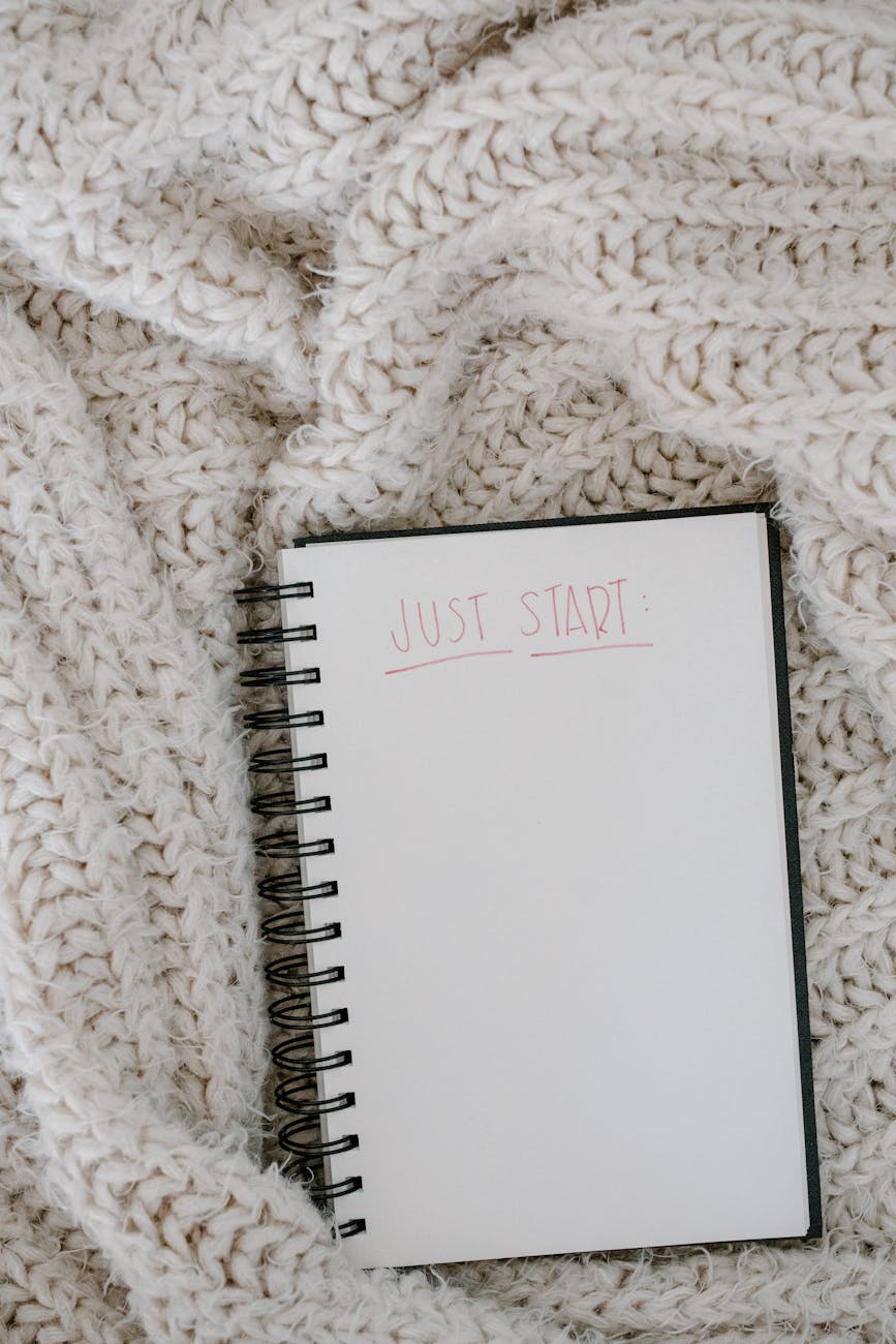 open notebook on white knitted fabric close up photo