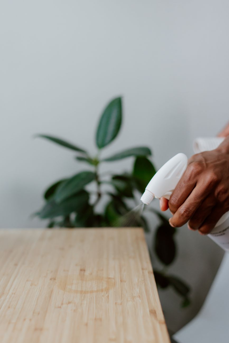 spraying coffee stain on table with cleaning product