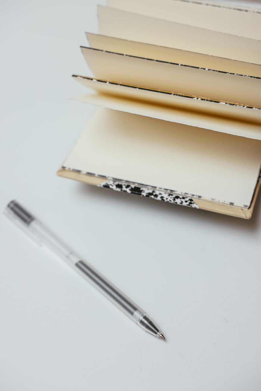 close up shot of a pen beside a notebook